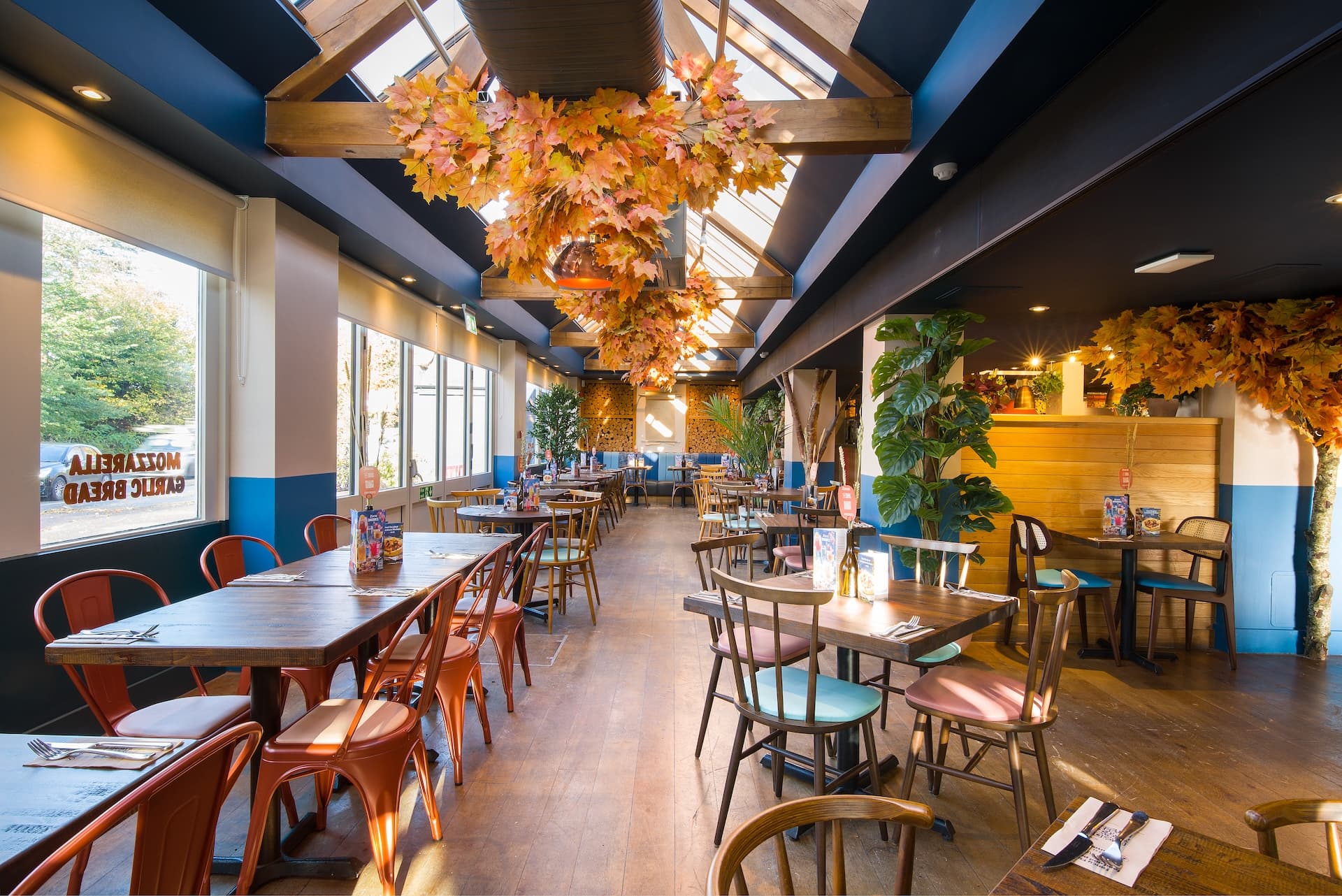 Zizzi Banstead, cozy dining under rich ceiling décor.