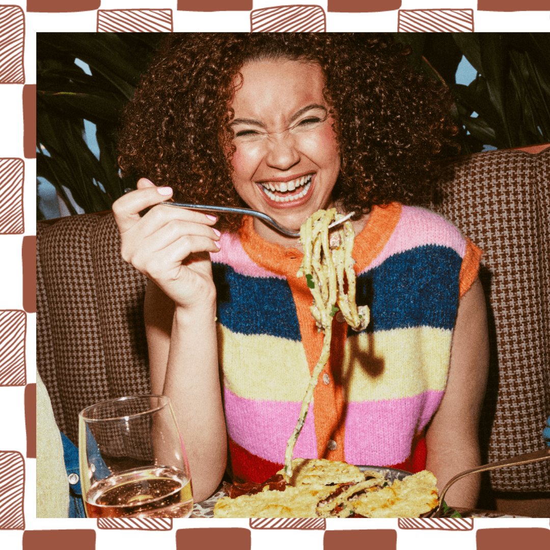 Woman eating pasta and smiling