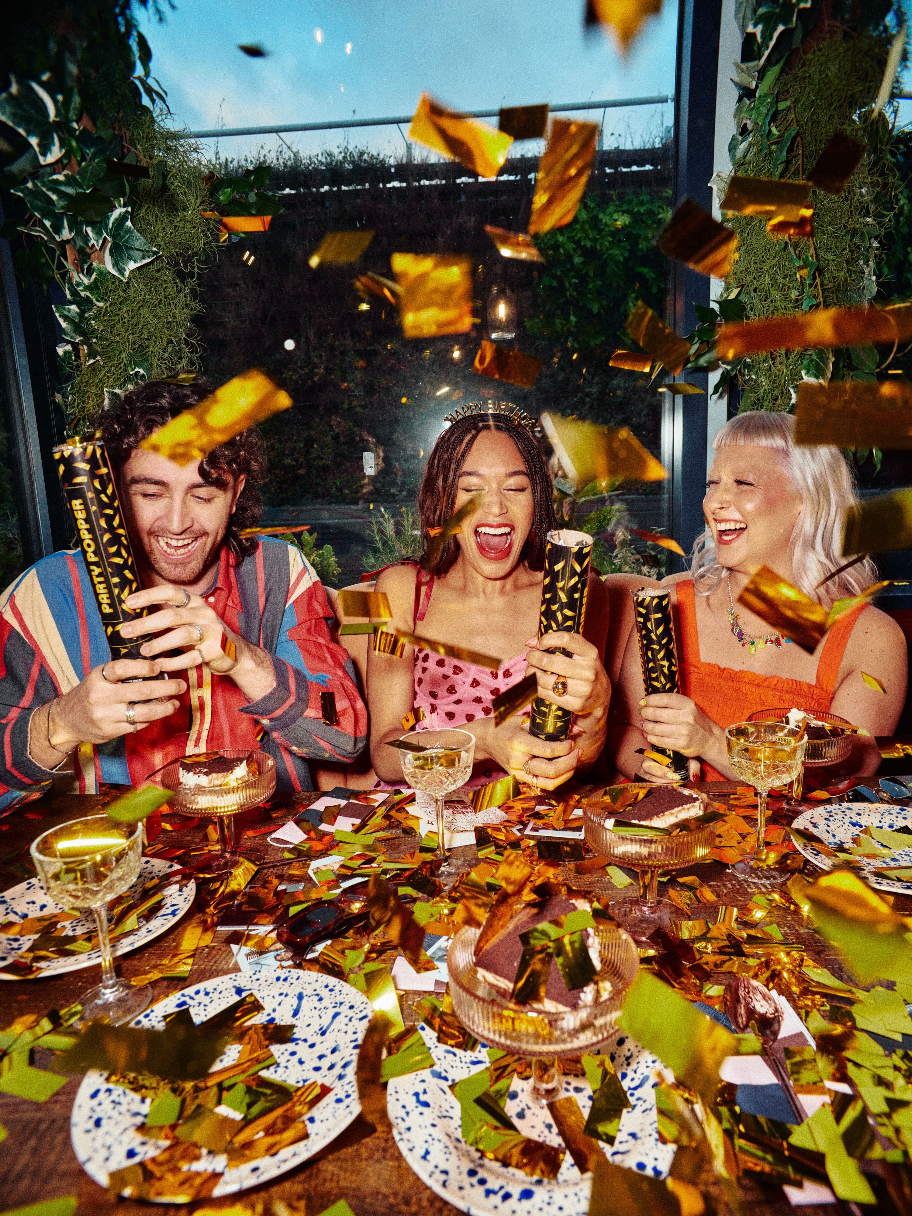 Friends celebrating birthday with gold confetti