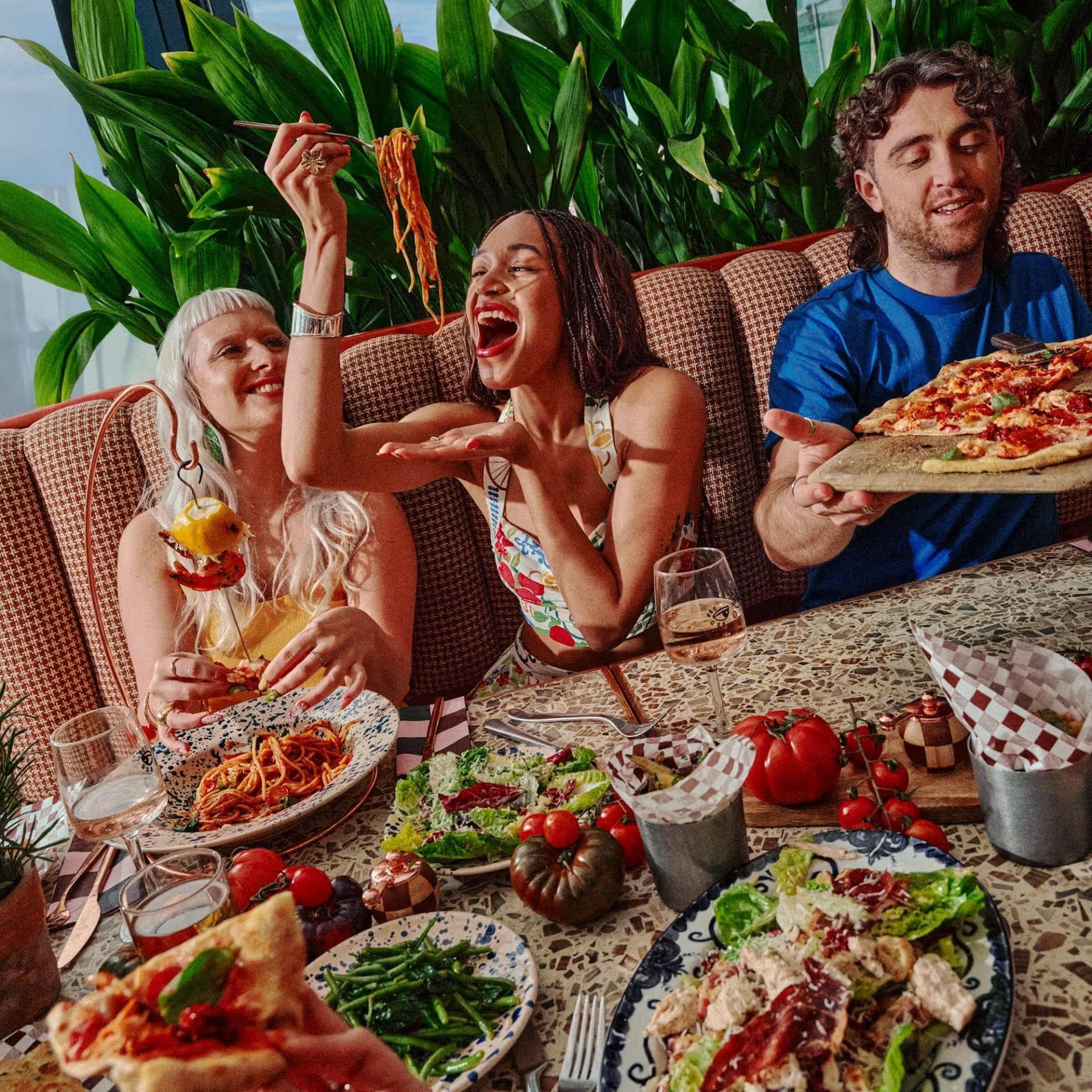 Group shot of friends sat around the table eating