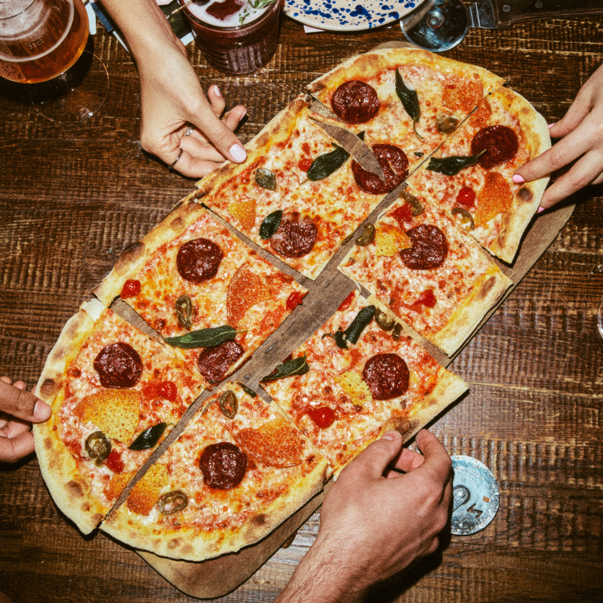 Hands picking up slices of Venison Pepperoni Rustica