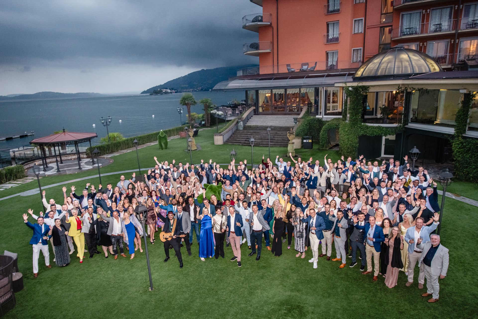 Group of team members waving to the camera at annual roadshow in Italy