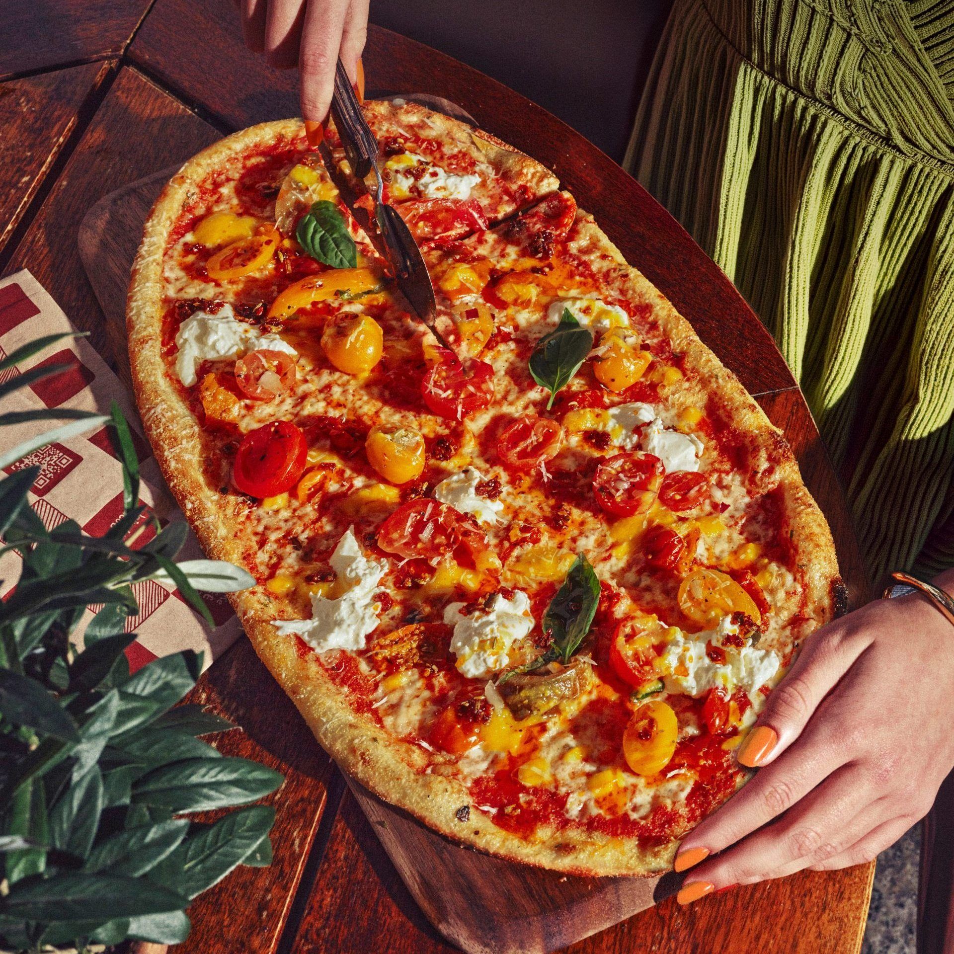 Quattro Pomodoro Rustica pizza with Isle of Wight heritage tomatoes, Sunblush tomatoes, Pomodoro sauce, Mozzarella, Burrata, Crispy Chilli Oil, Yellow Pepper & Pomodoro sauce. 